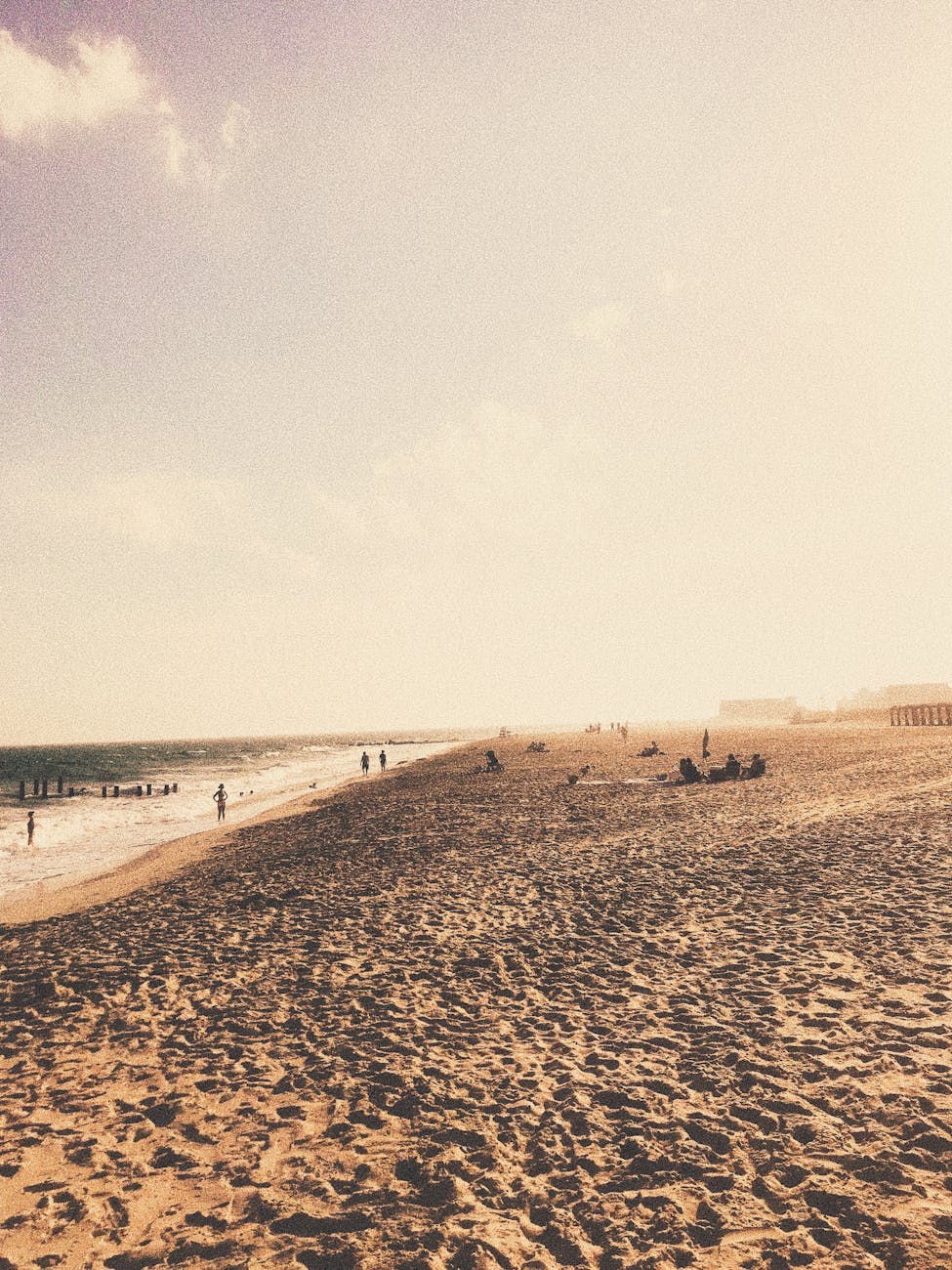 people on sandy seashore near waving sea